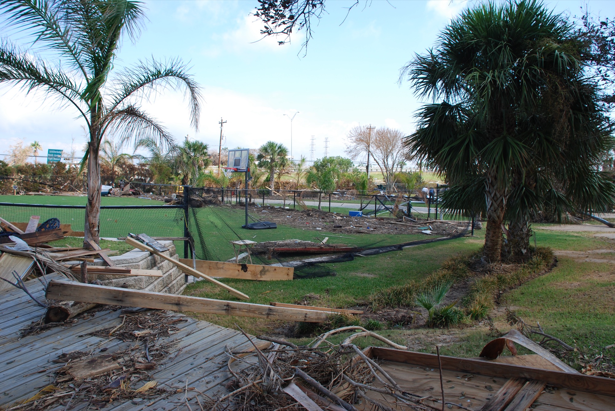Storm debris and torn fencing beside the court after Hurricane Ike